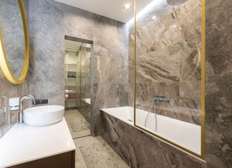 Marble bathroom with a vanity and a bathtub